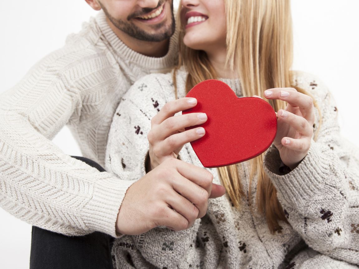 Влюбленная пара с красным сердцем в руках