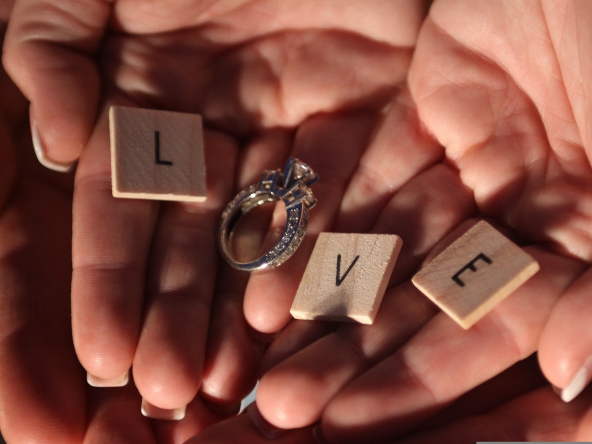 Кубики и кольцо на ладонях с надписью любовь