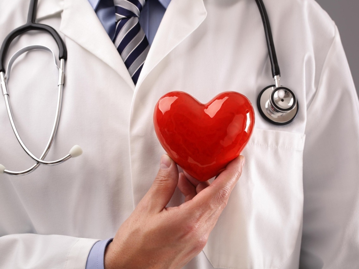 Красное сердце в руках доктора в белом халате