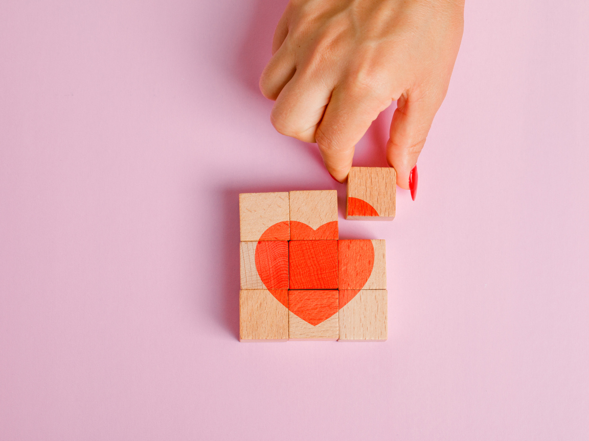 Красное сердце из кубиков на розовом фоне