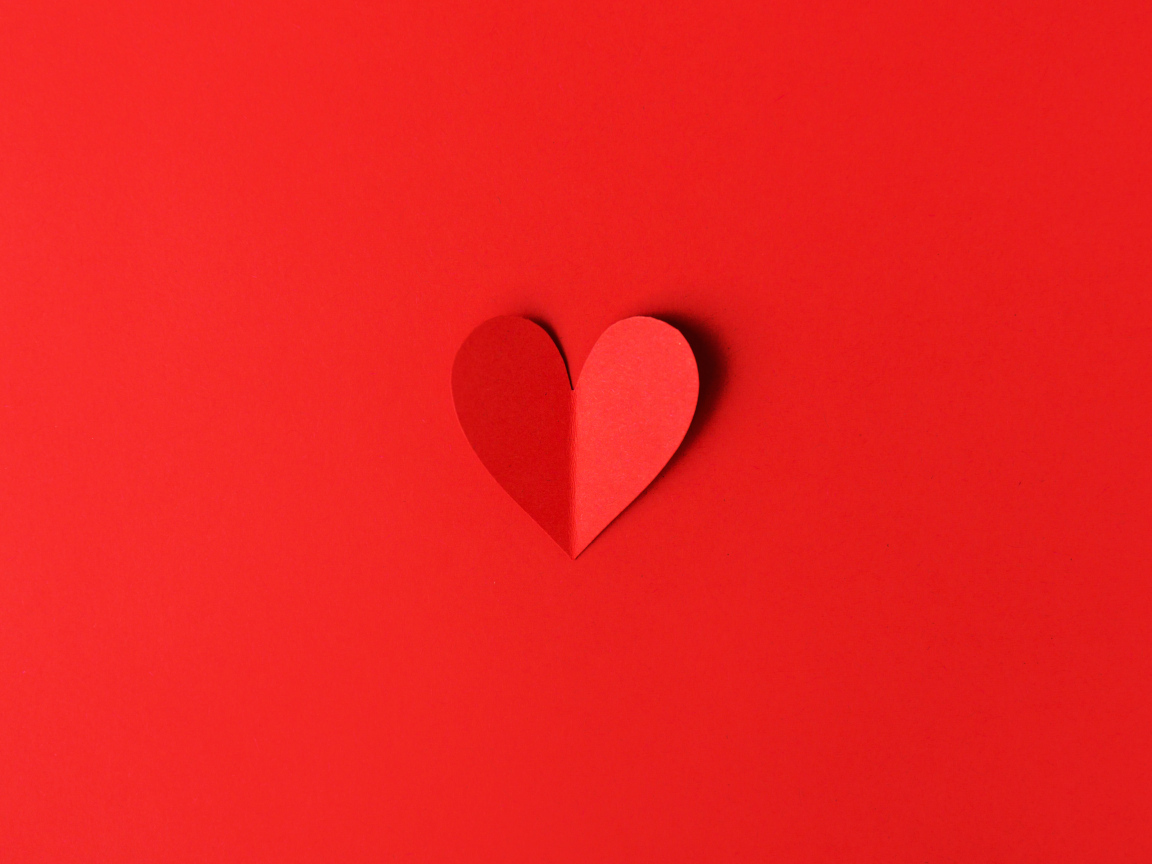 Маленькое бумажное сердце на красном фоне