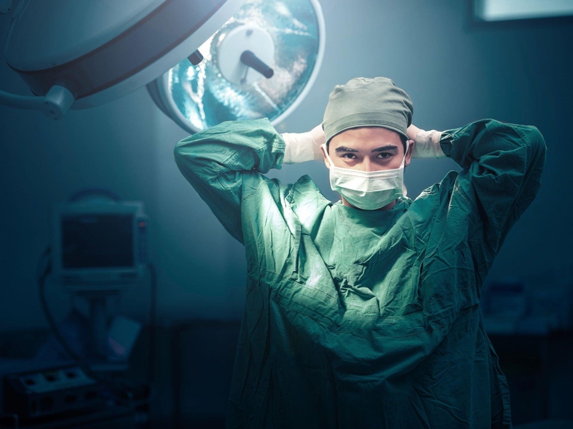 Мужчина врач в костюме в операционной