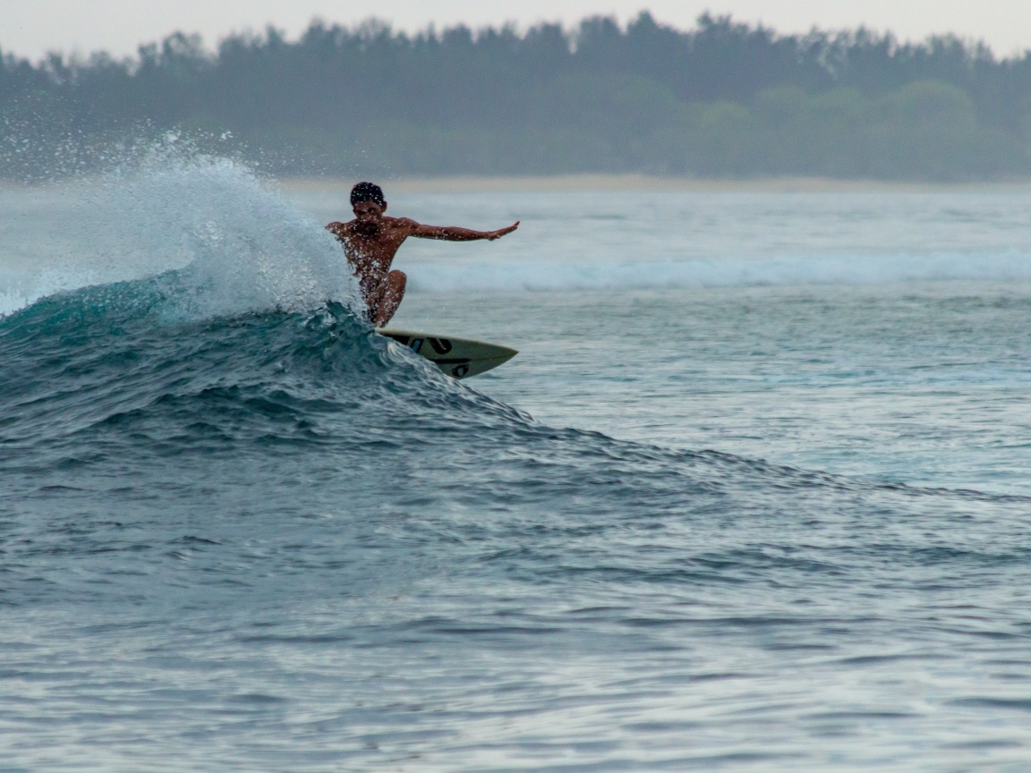 Мужчина серфингист ловит волну