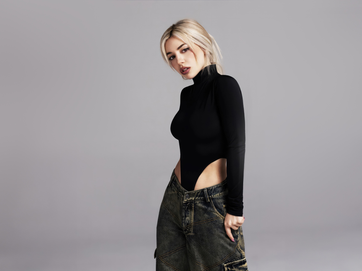 Милая блондинка певица  Эйва Макс на сером фоне