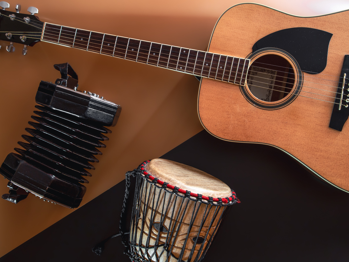 Гитара, гармошка и барабан на столе