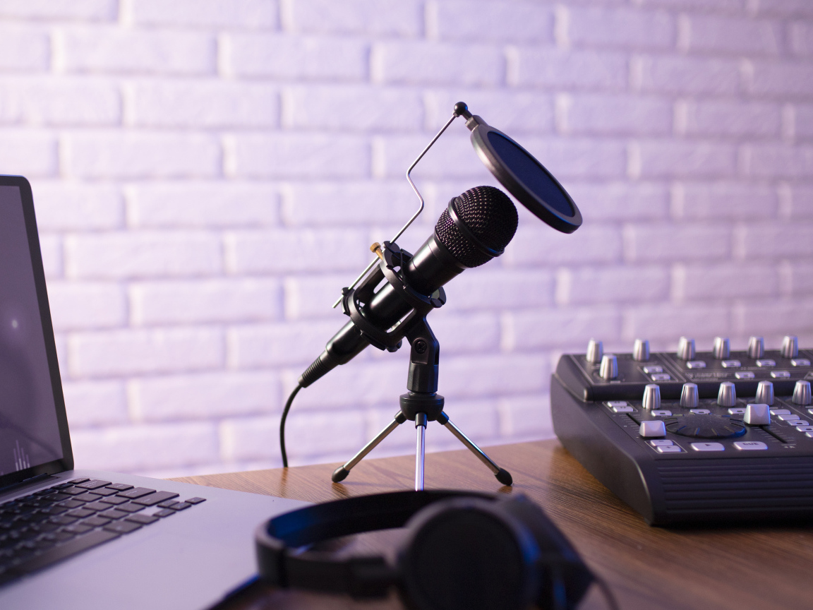 Микрофон на столе с микшером и ноутбуком