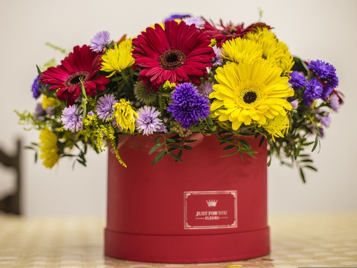 Букет разноцветных цветов в корочке на столе