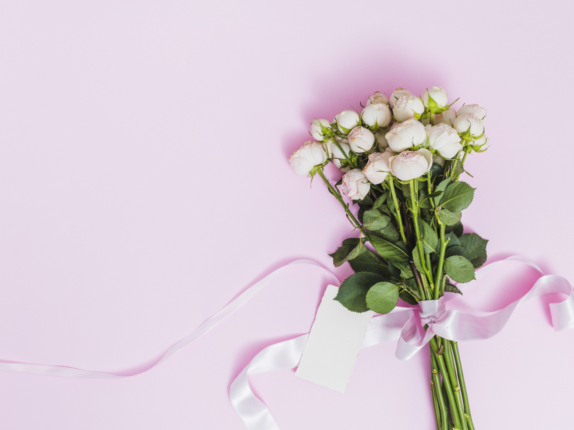 Букет роз с лентой на розовом фоне