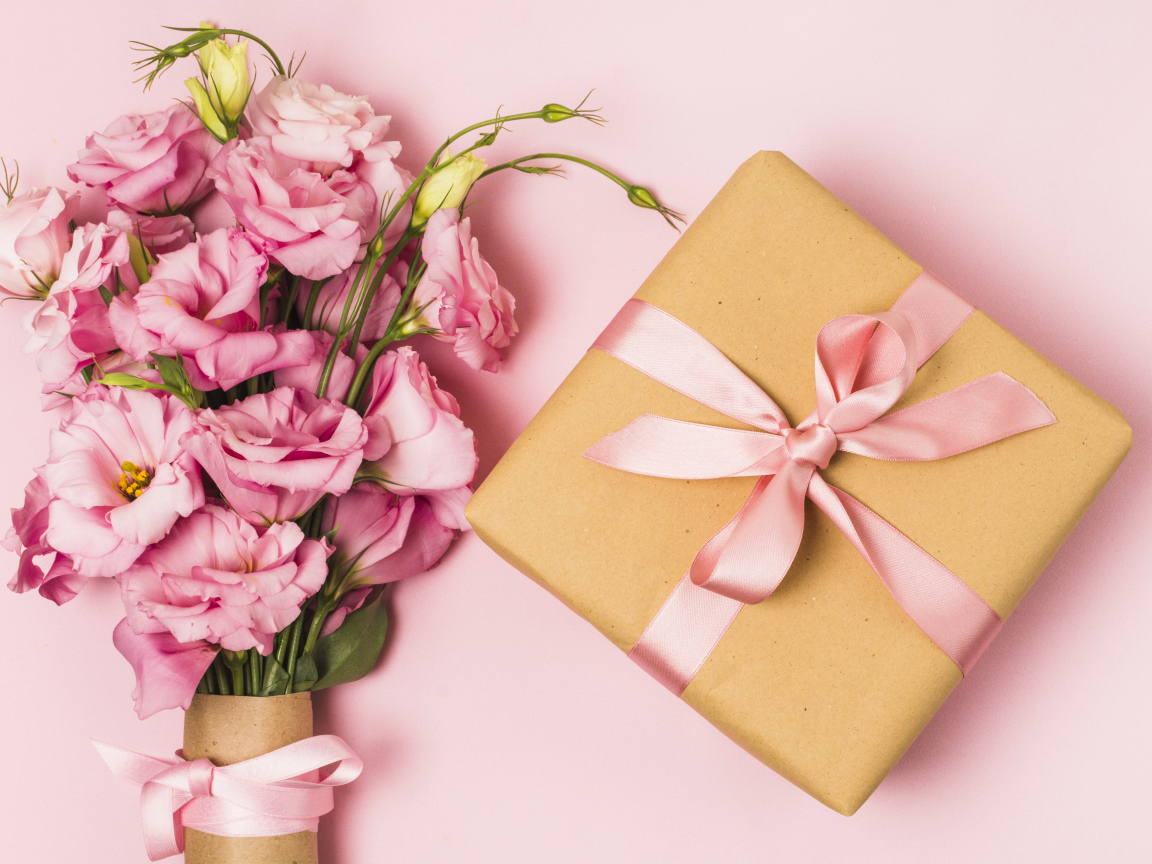 Большой букет эустомы с подарком на розовом фоне