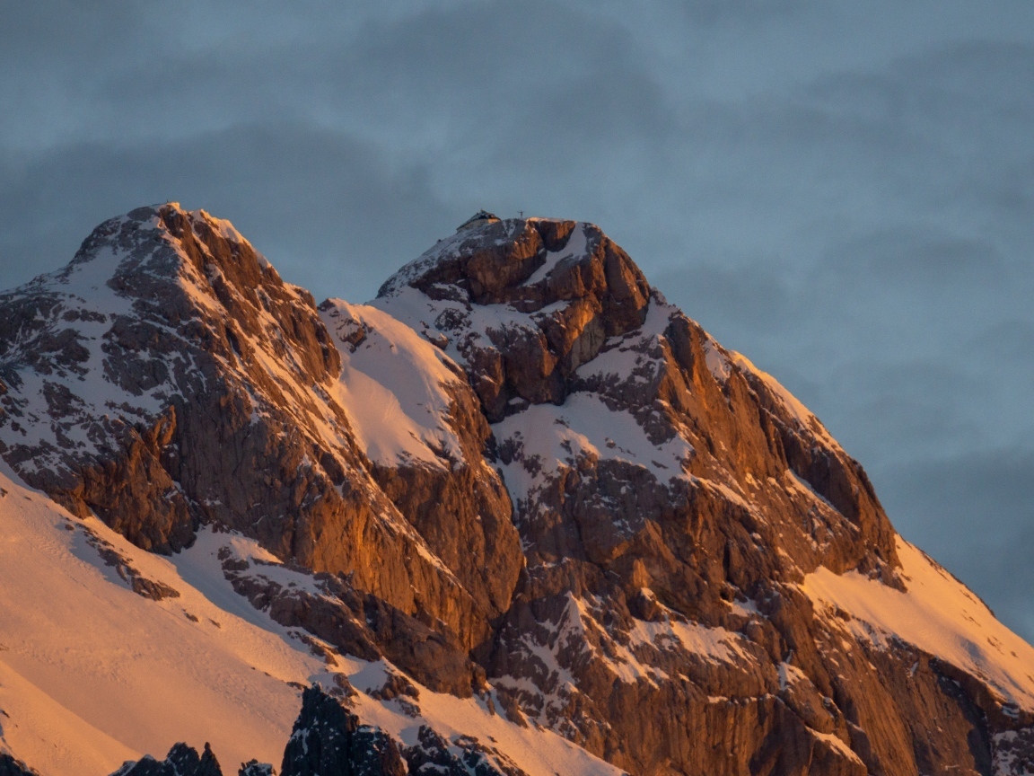 Высокие опасные заснеженные горы под грозовым небом