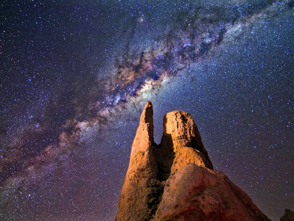 Млечный путь в звездном небе над острой  горной вершиной
