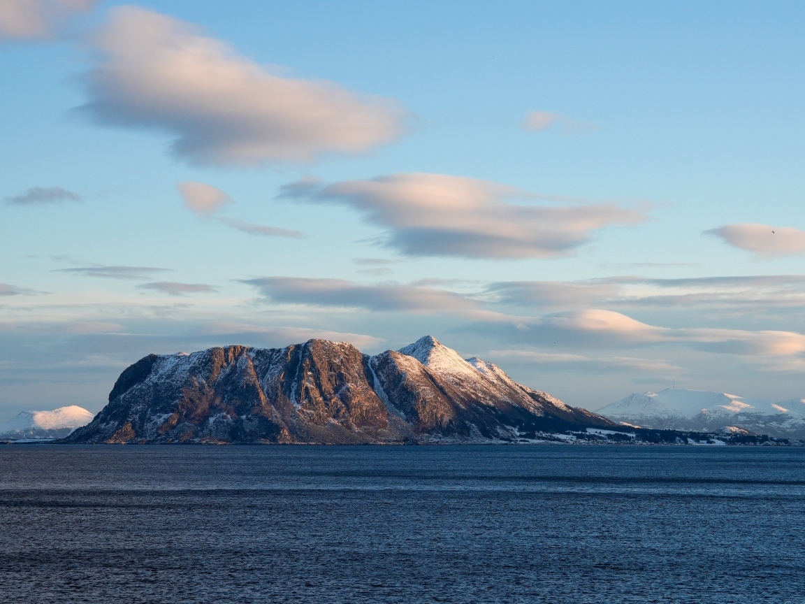 Скала в лучах солнца в море