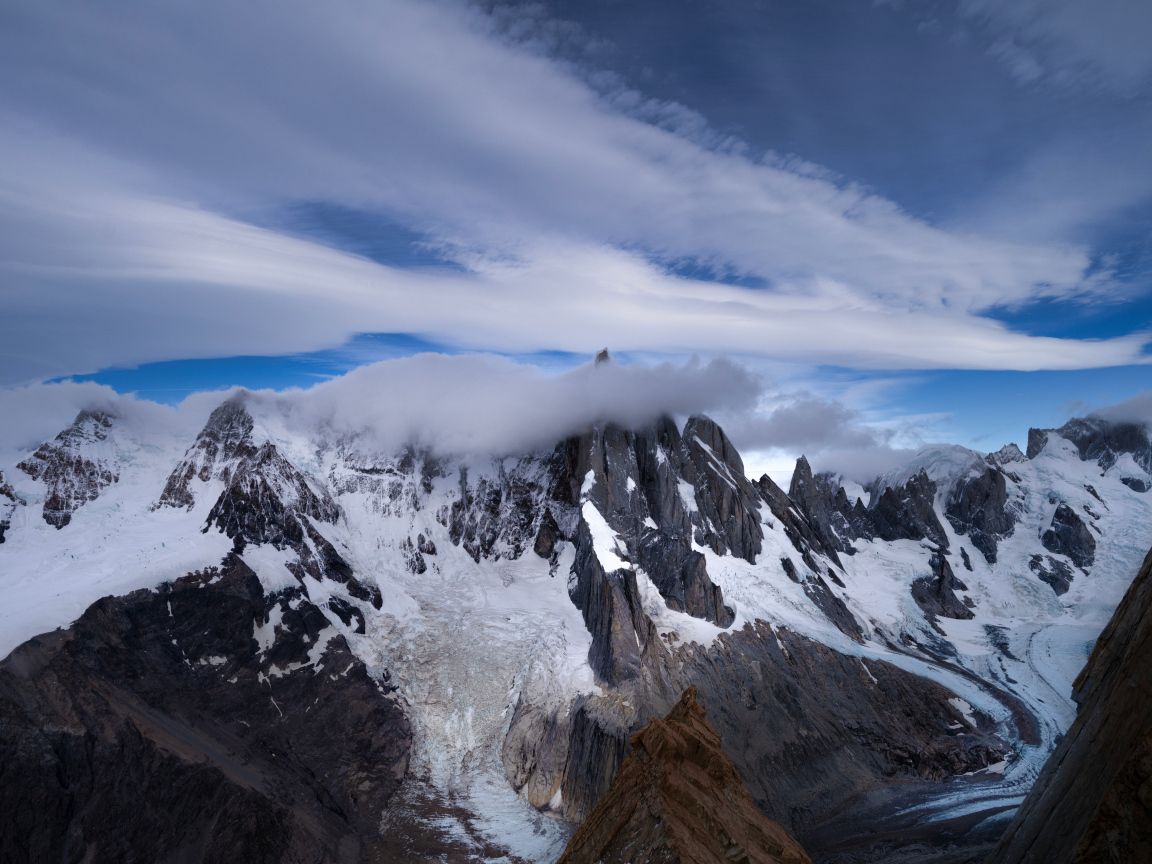 Белые облака над холодными заснеженными горами