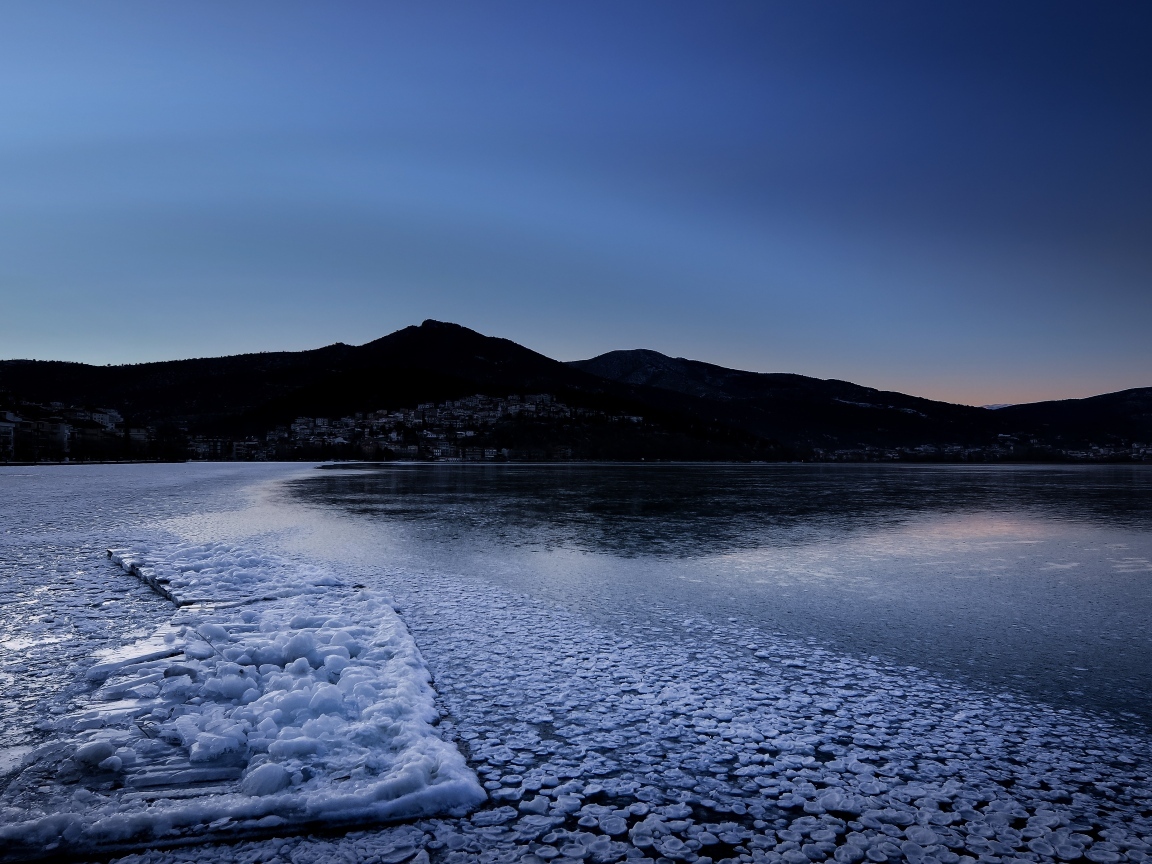 Заледеневшая вода в горном озере в сумерках