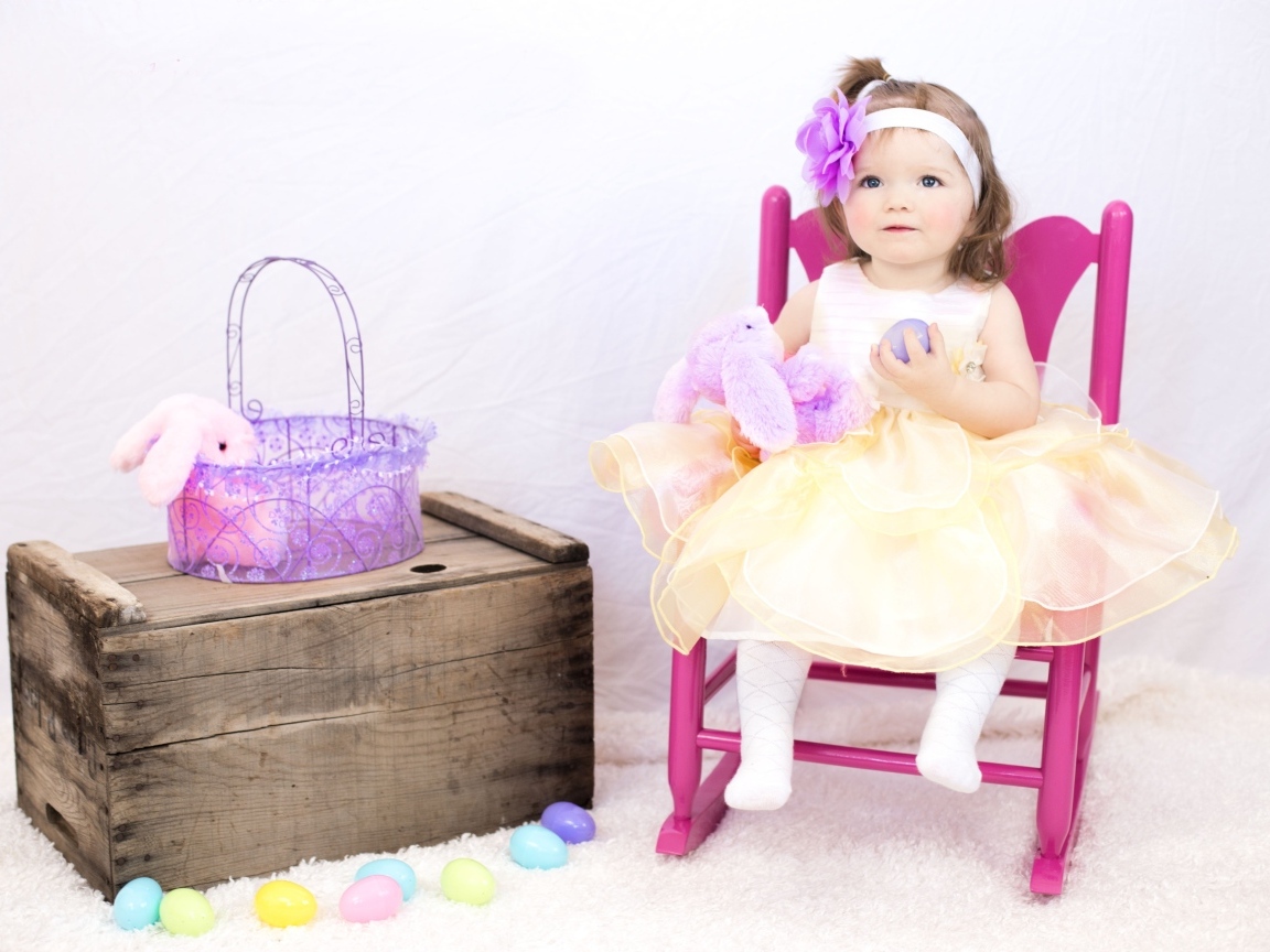 Девочка в красивом платье сидит на стуле 