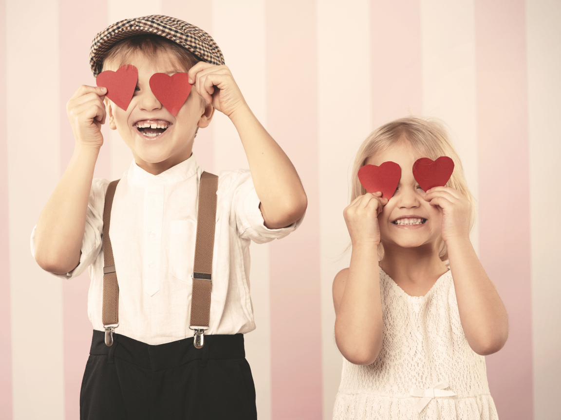 Мальчик и девочка с сердечками в руках