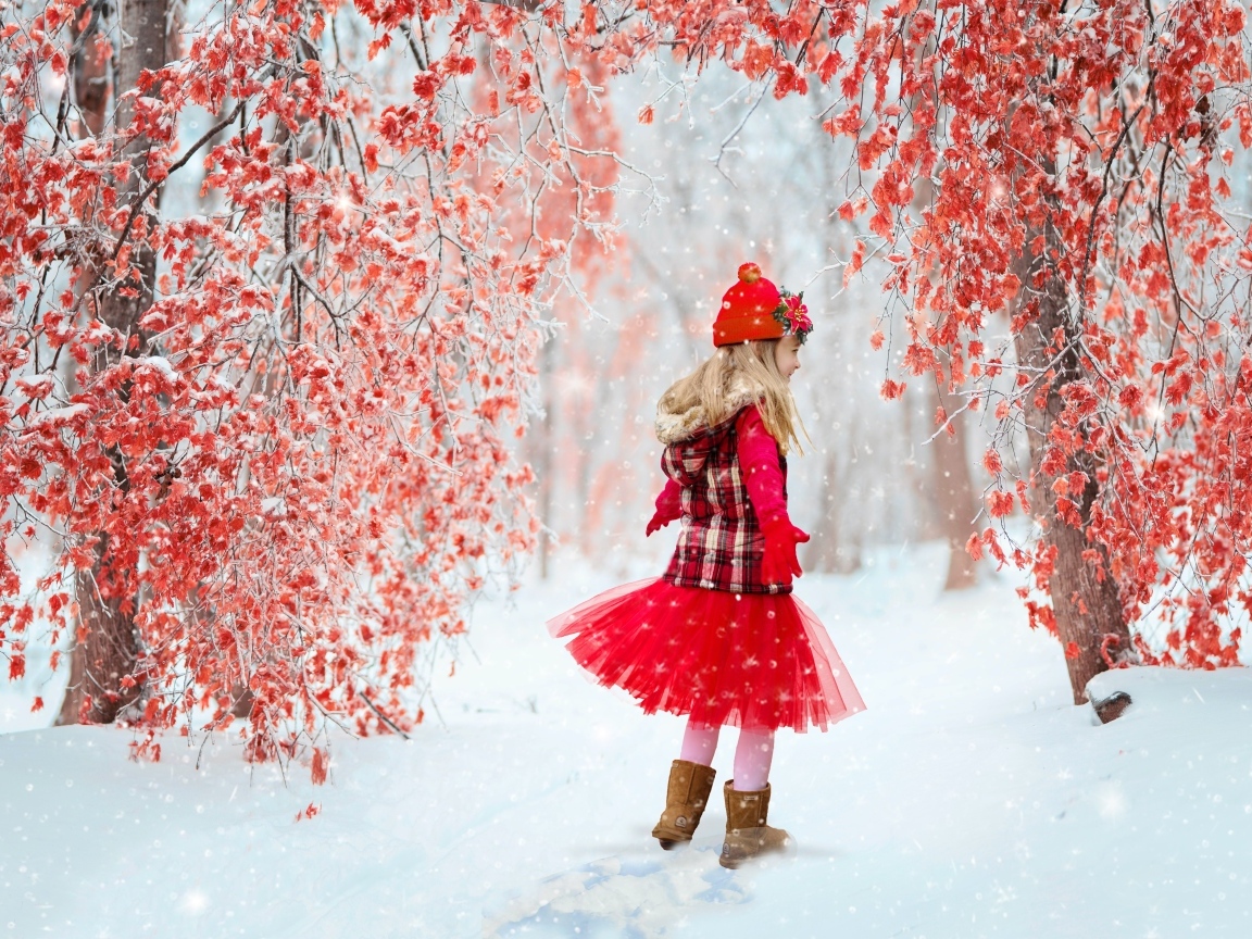 Милая девочка в заснеженном лесу с деревьями с красными листьями