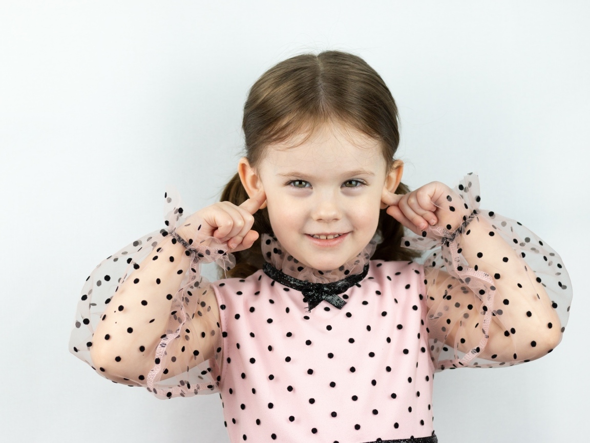 Смешная маленькая девочка закрыла уши