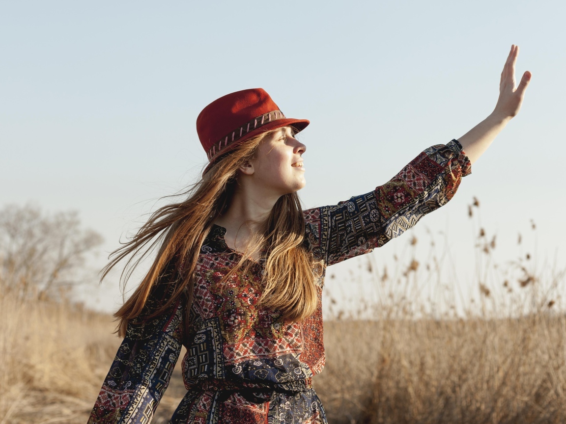Девочка в шляпе на поле в лучах солнца