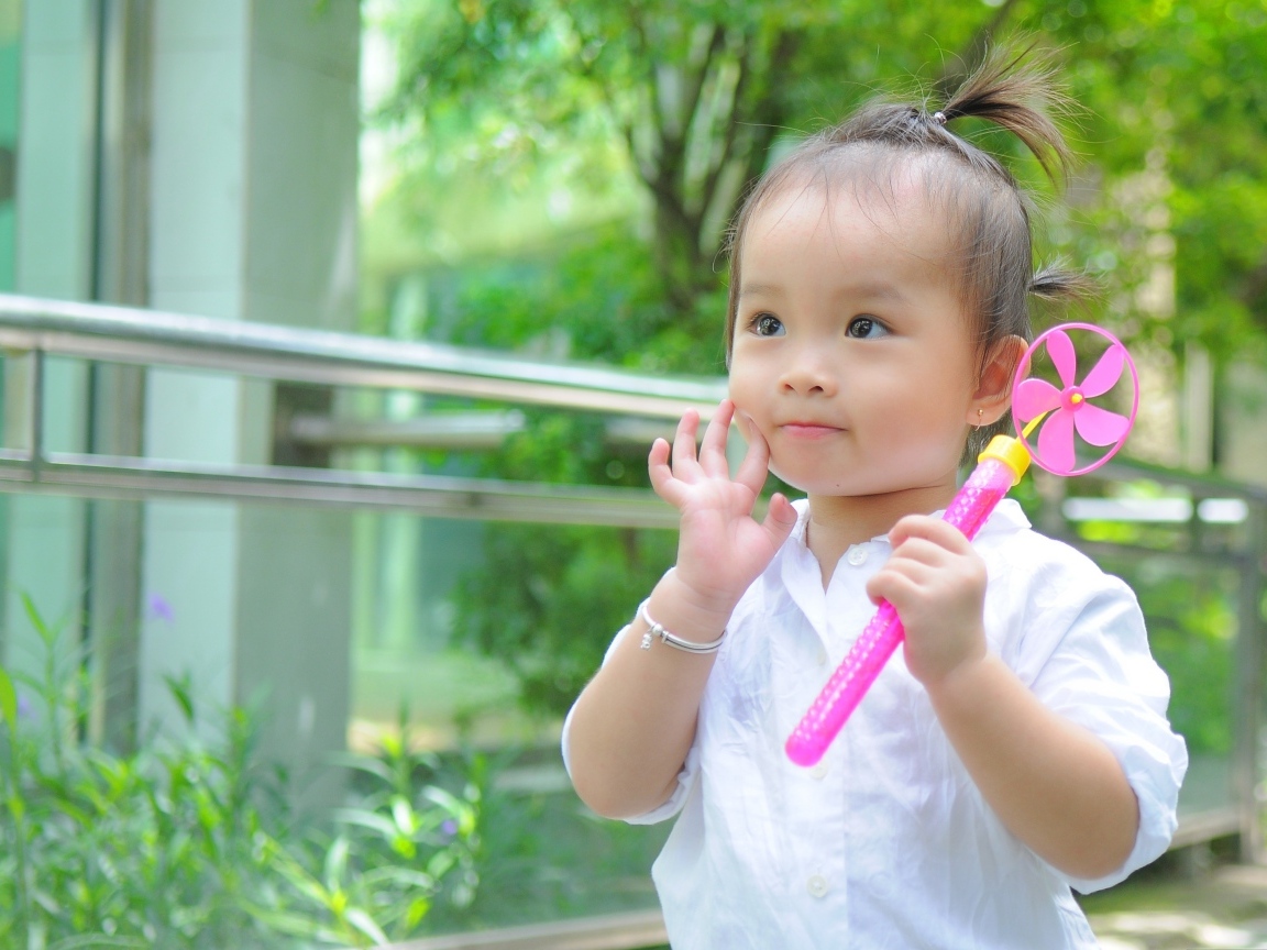 Маленькая девочка азиатка с игрушкой в руках