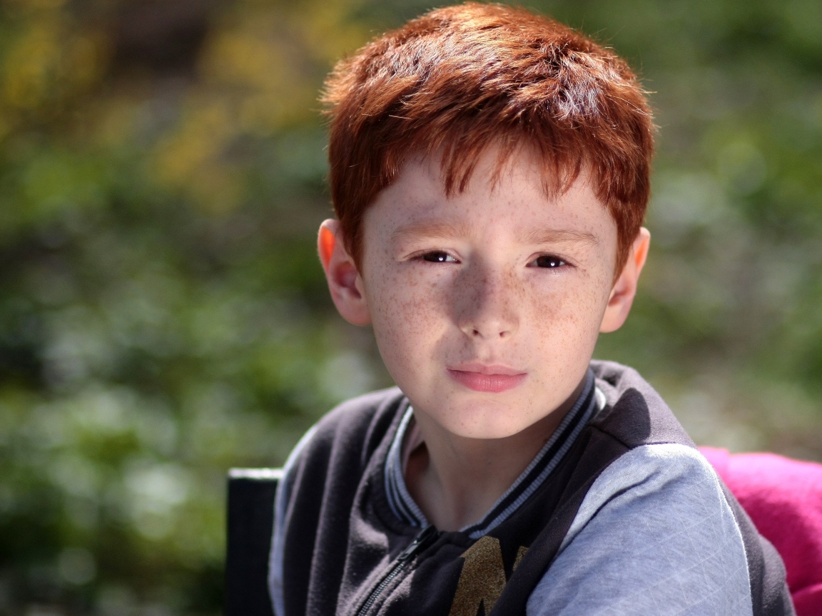 Маленький рыжеволосый мальчик с веснушками на лице