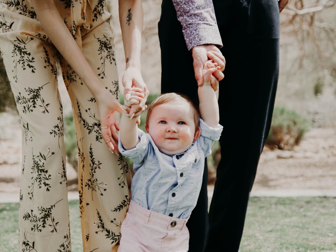 Родители ведут маленького ребенка