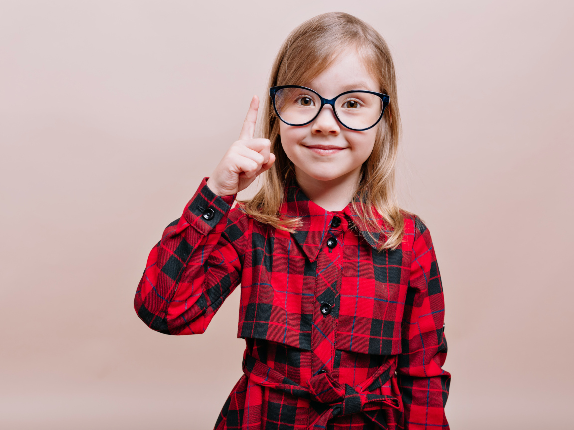 Умная маленькая девочка в платье в очках