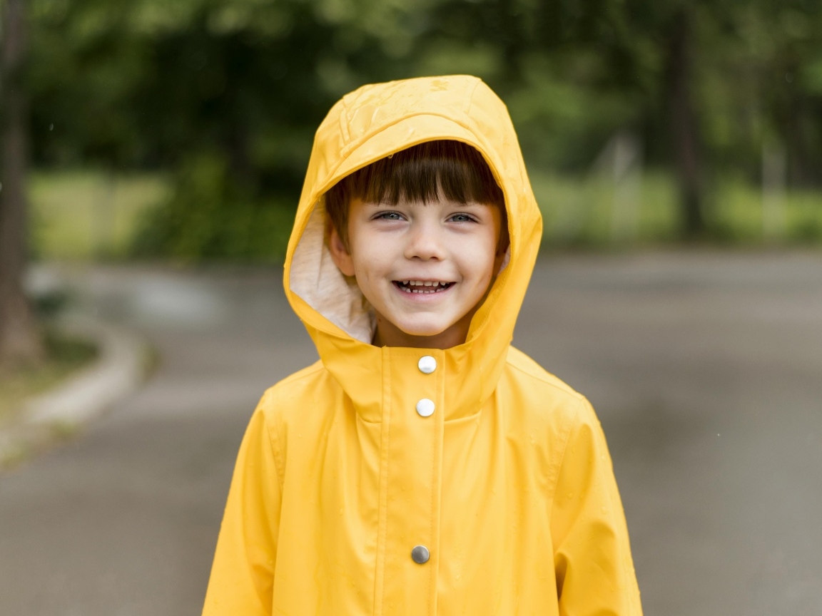 Улыбающийся мальчик в желтой куртке