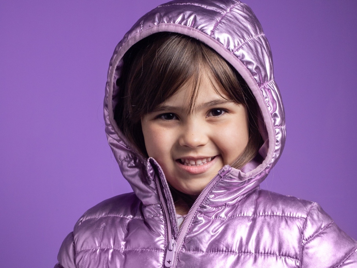 Улыбающаяся девочка в сиреневой куртке