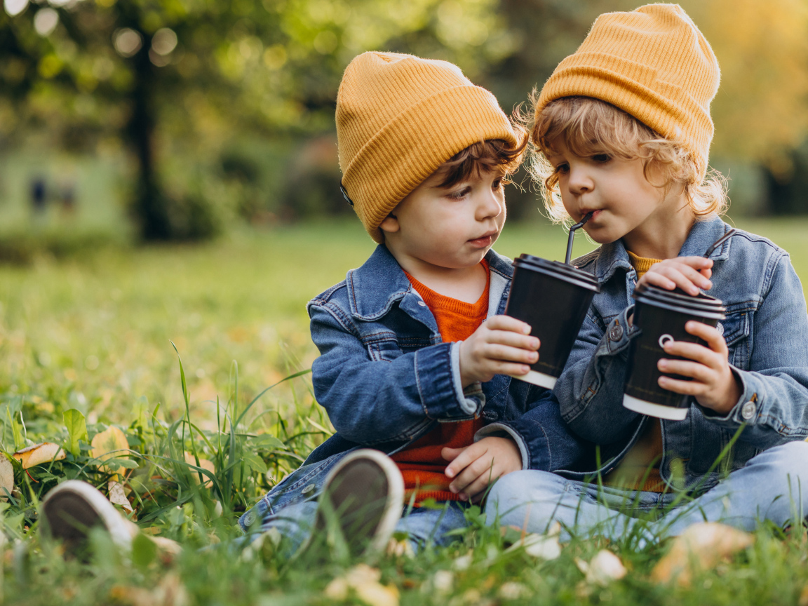 Два маленьких  брата сидят на траве