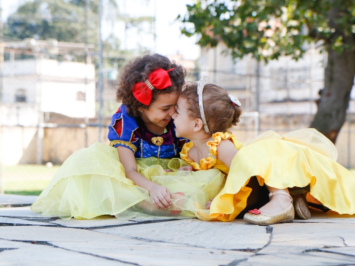 Две маленькие сестры играют под деревом