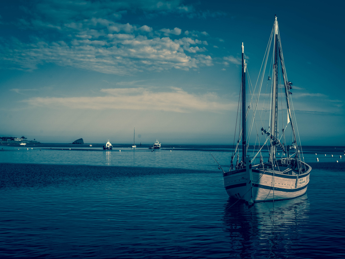 Парусная лодка в гавани в сумерках