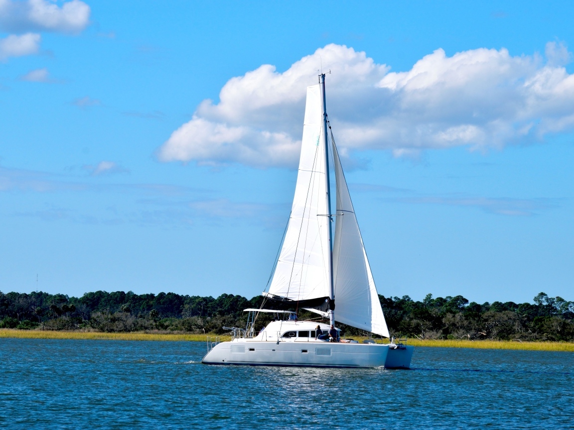 Парусная яхта в море на фоне красивого неба