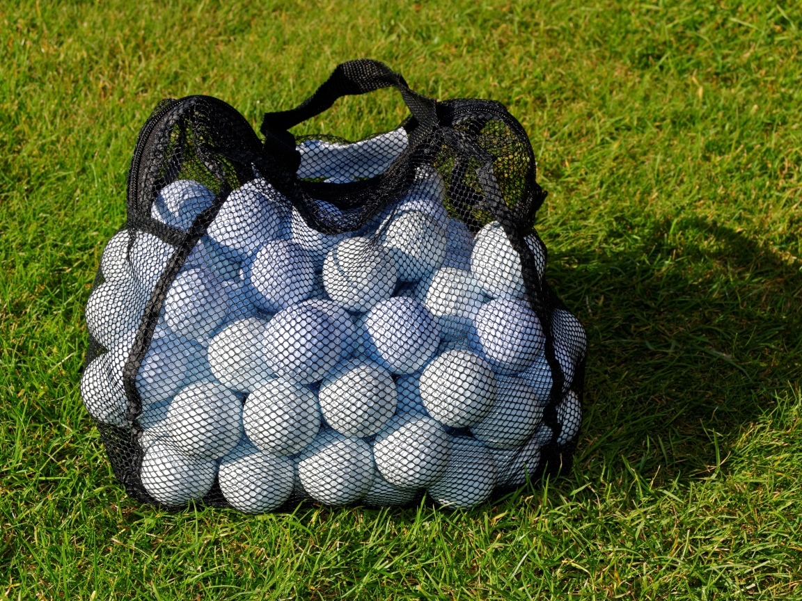 Сетка с мячами для гольфа на траве