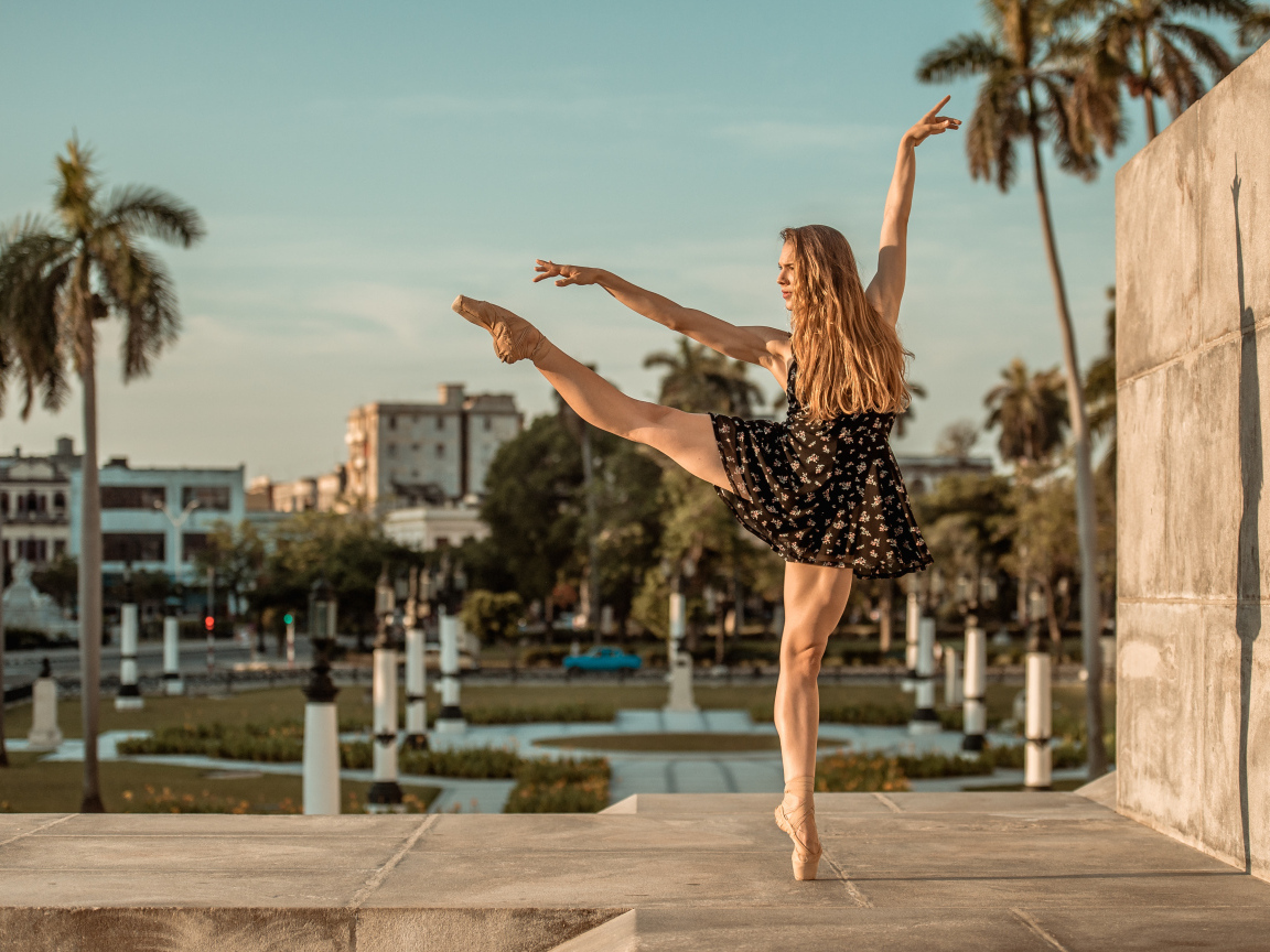 Балерина в лучах солнца у стены