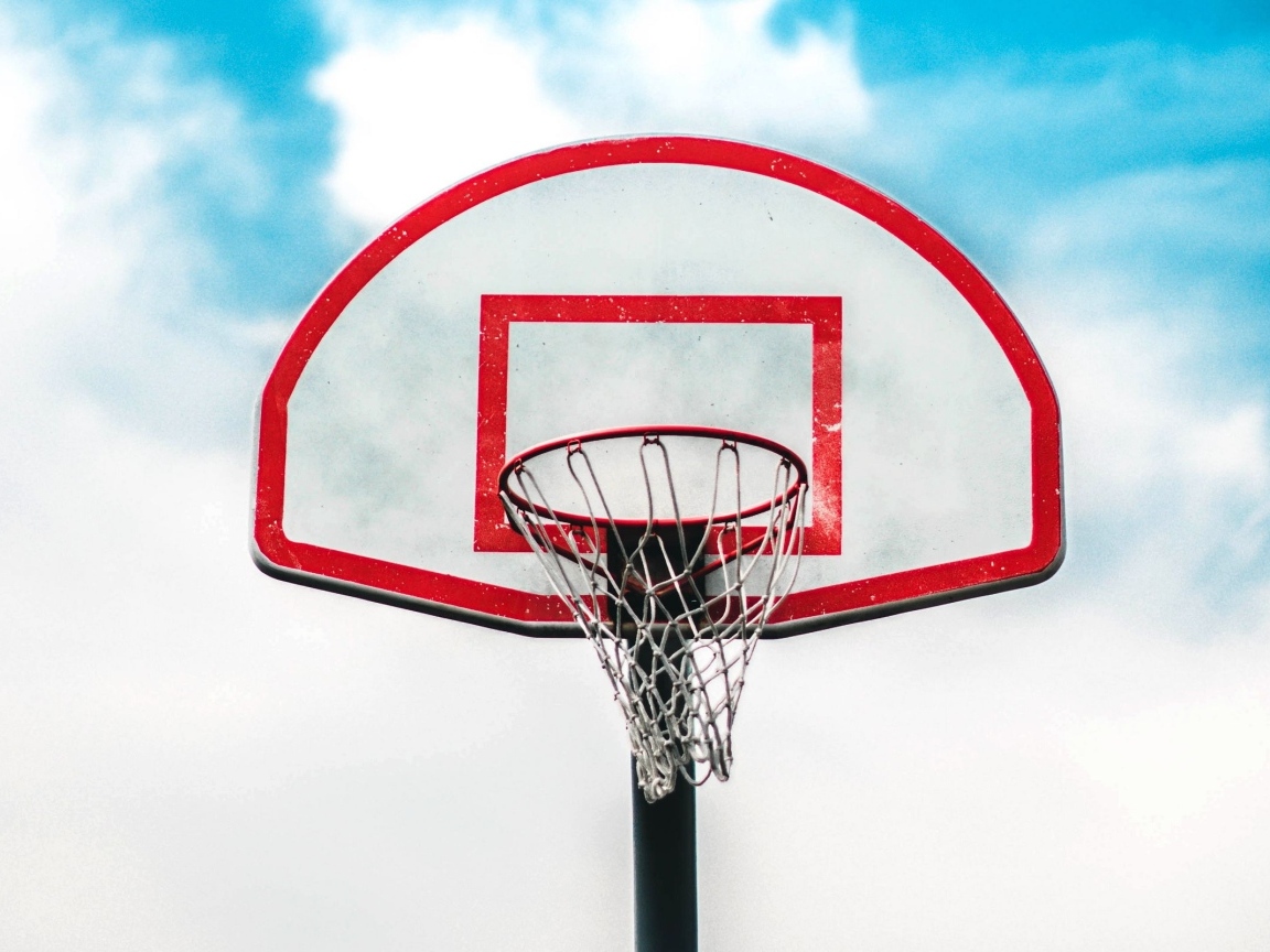 Баскетбольное кольцо на фоне белых облаков