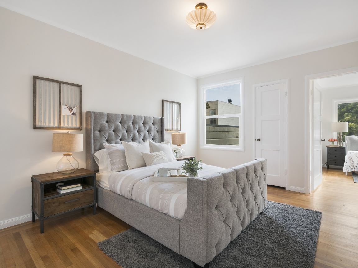 Высокая серая кровать в спальной комнате