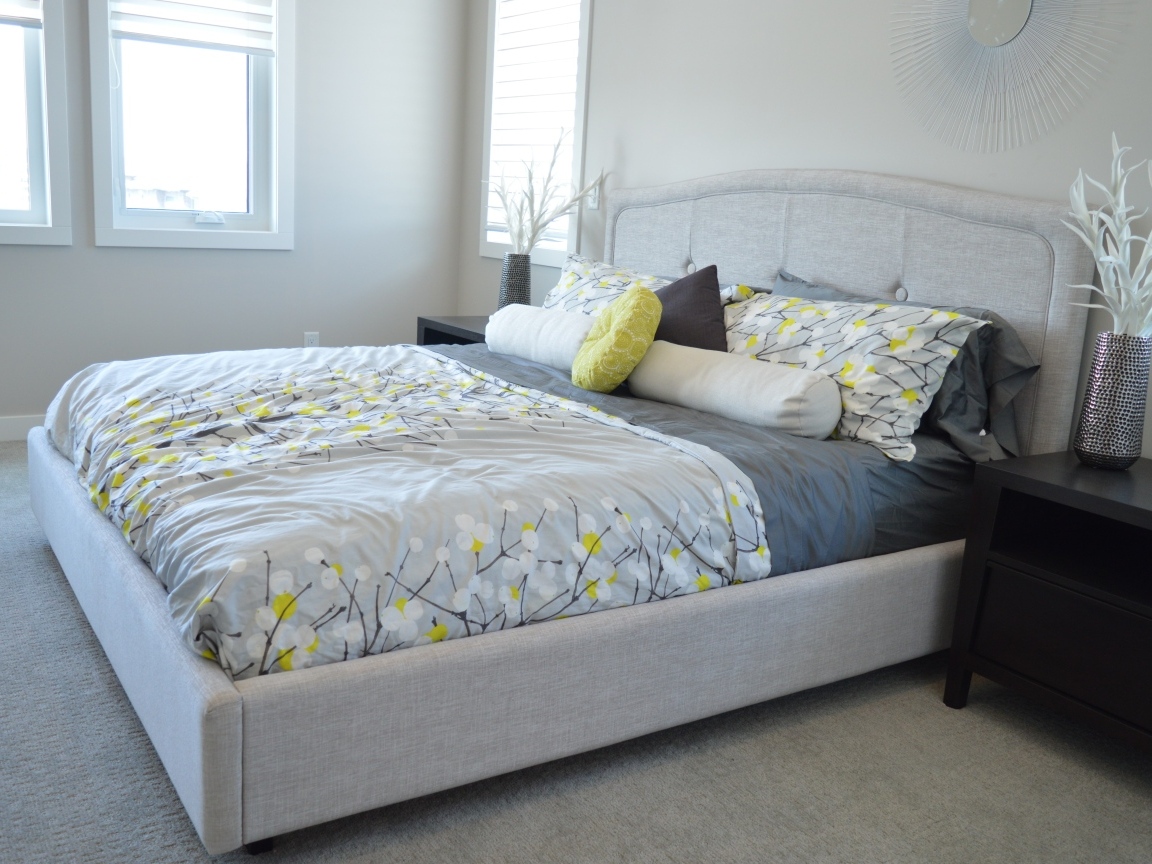 Большая мягкая кровать в серой спальне