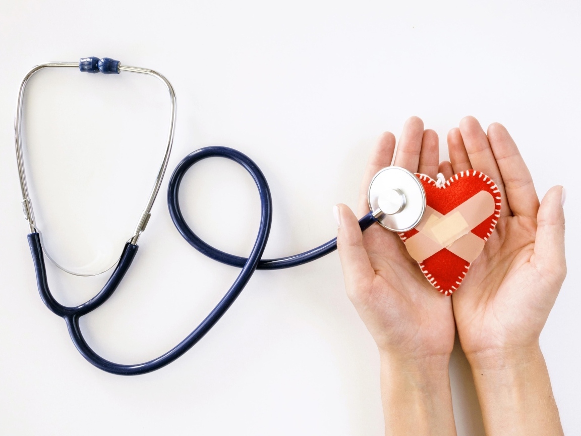 Стетоскоп слушает раненое сердце в ладонях