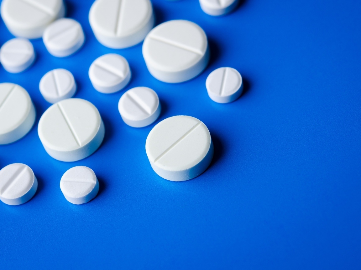 Белые таблетки на синем фоне