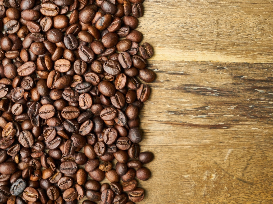 Ароматные жареные зерна кофе на деревянном столе