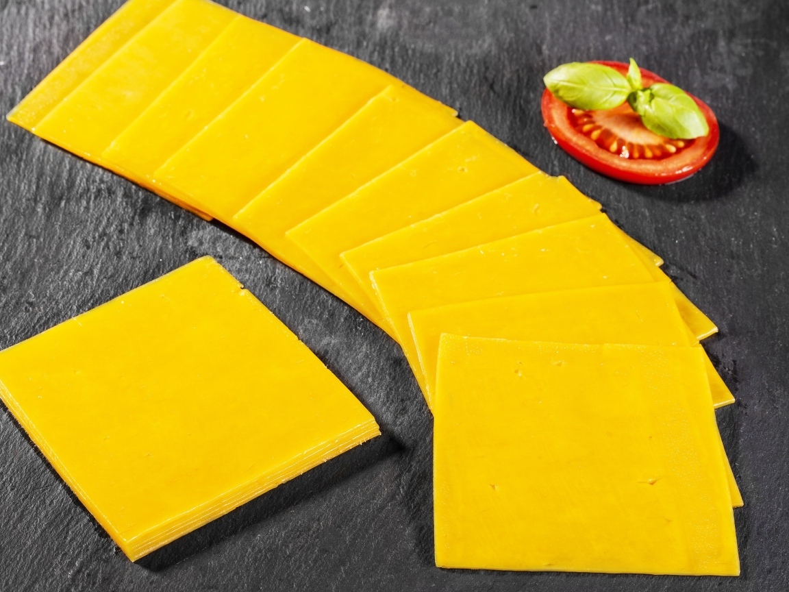 Ломтики сыра с помидором на столе