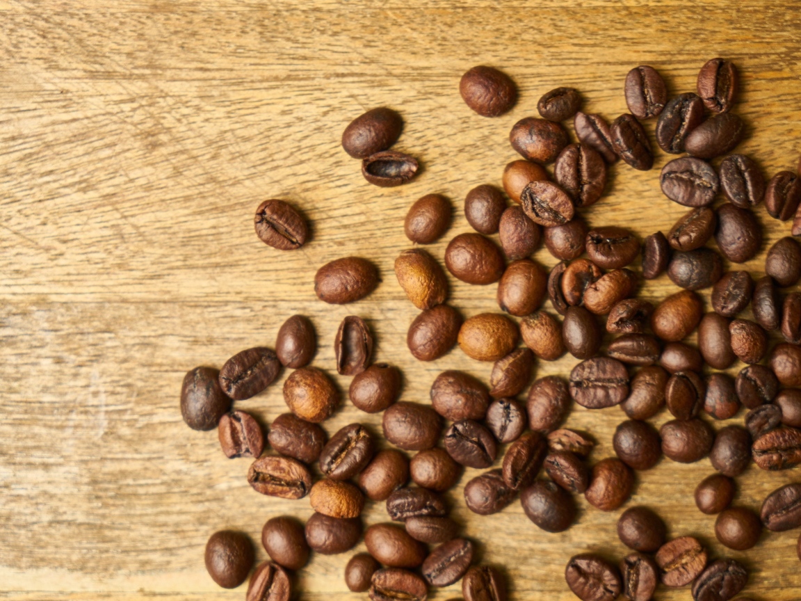 Жареные кофейные зерна на деревянном столе