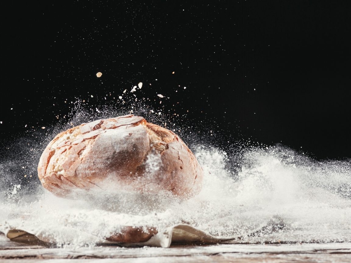 Буханка хлеба в муке на столе