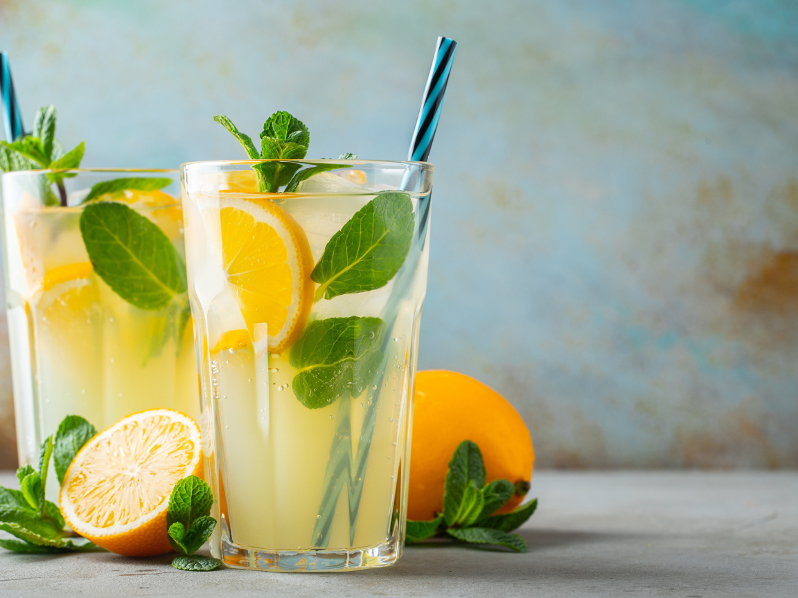 Два стакана лимонада на столе с лимоном