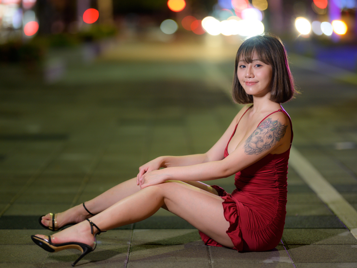 Азиатка с татуировкой на руке в красном платье