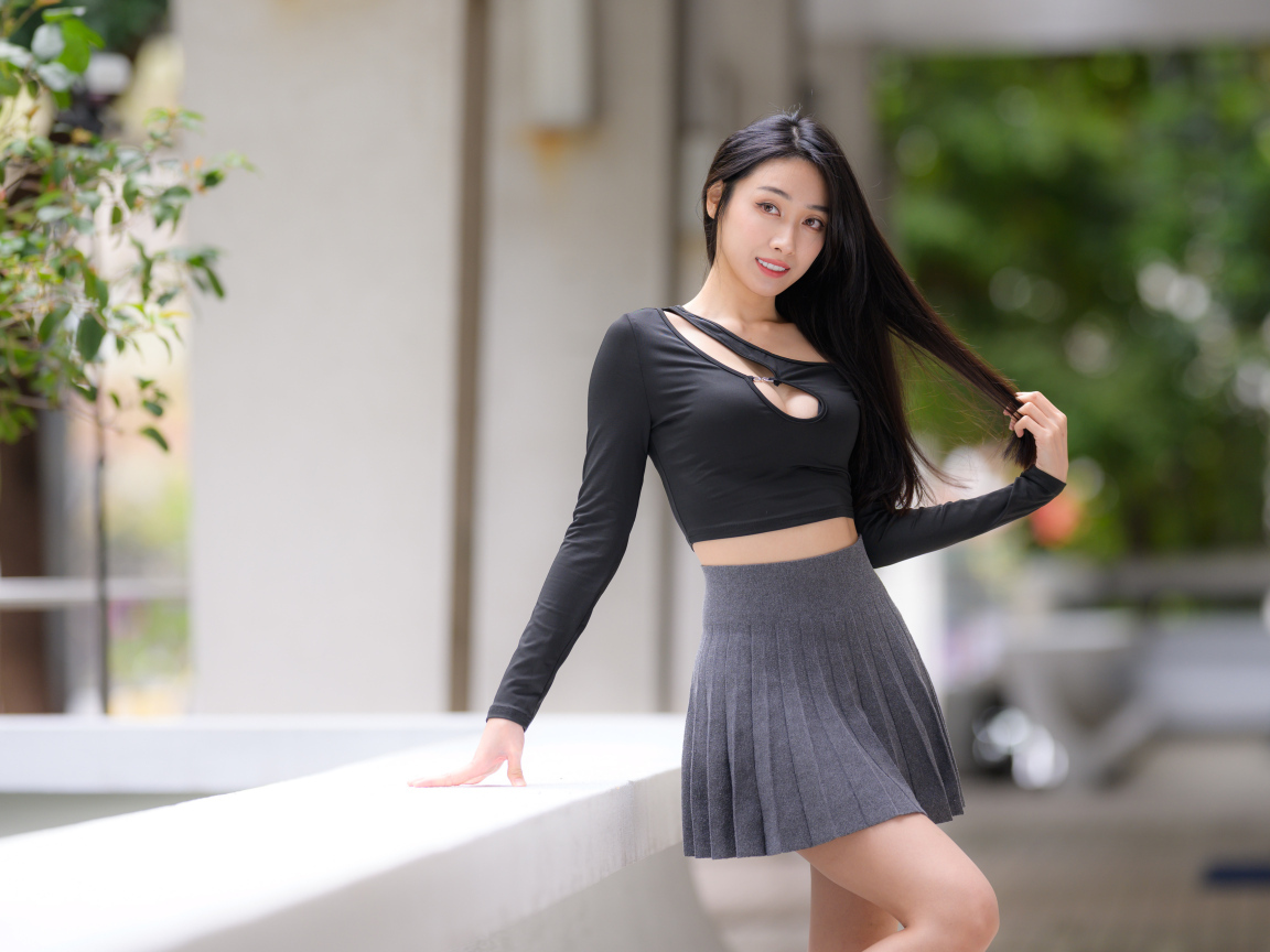 Молодая азиатка в короткой серой юбке