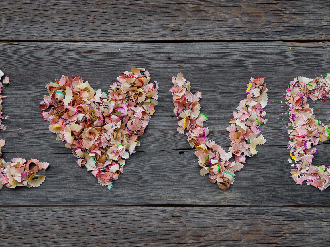 Надпись любовь из стружки карандашей на деревянном фоне