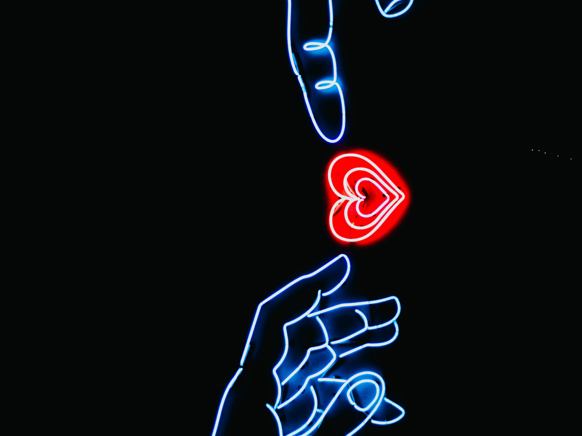 Неоновое красное сердце с руками на черном фоне