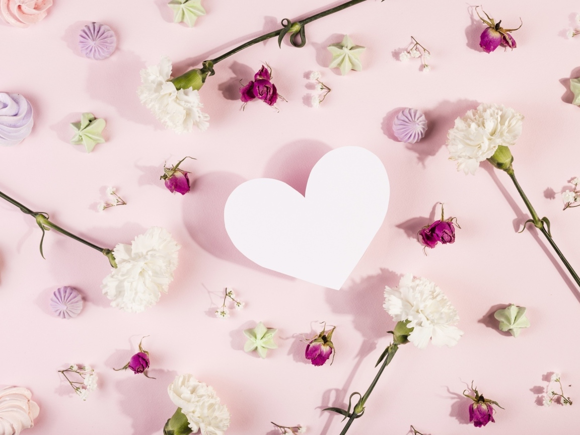 Белое бумажное сердце на розовом фоне с цветами